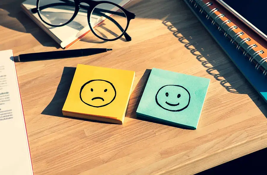 Image of sticky notes with a happy face and sad face on each pad
